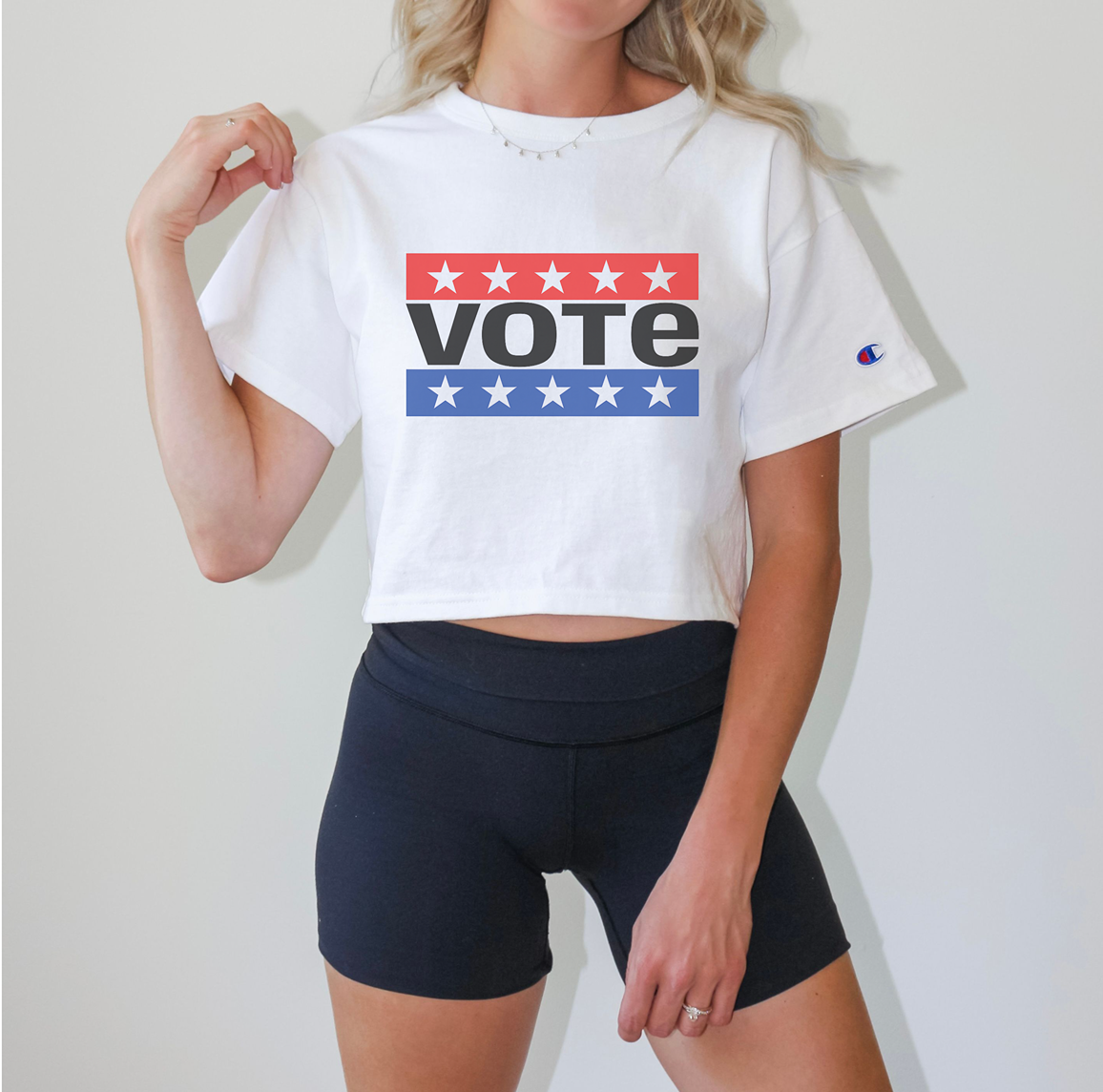woman wearing a white crop top that says vote