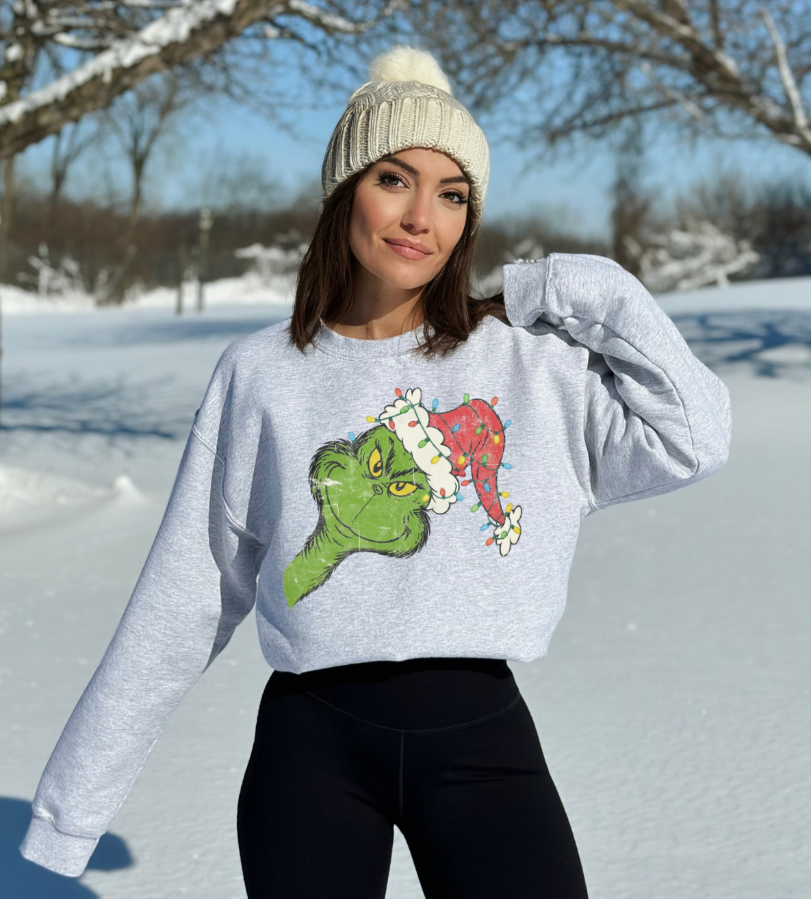 woman wearing an ash grey grinch christmas sweatshirt