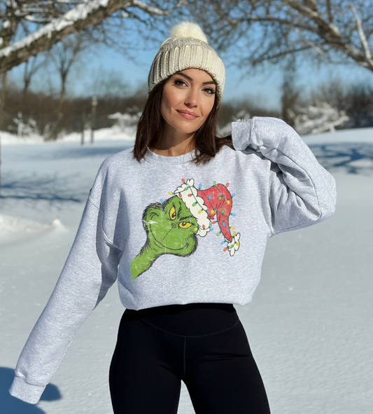 woman wearing an ash grey grinch christmas sweatshirt
